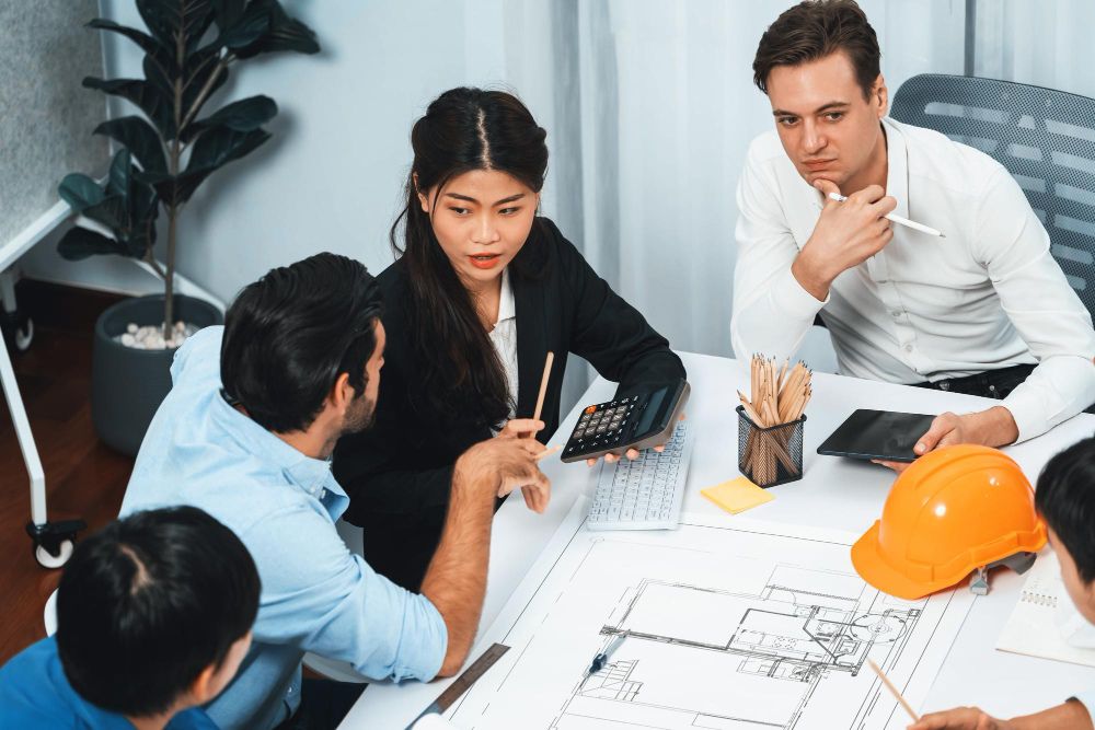 Construction recruiter reviewing skilled candidates from multiple construction disciplines, including engineers, site managers, electricians and tradespeople, in a modern UK recruitment office