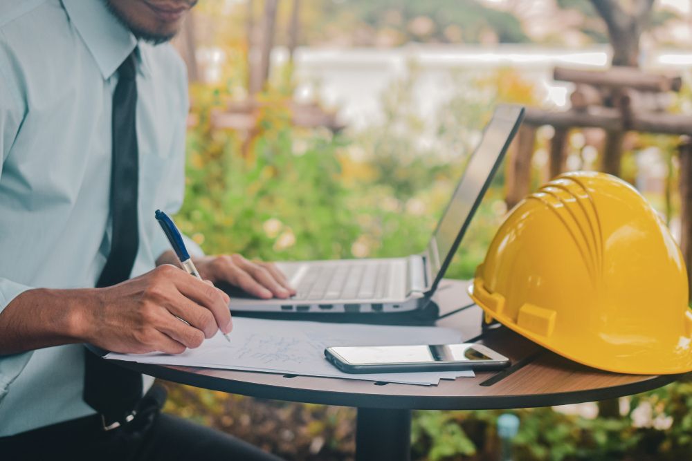 Recruitment compliance specialist verifying CSCS cards, right-to-work documents and candidate qualifications alongside construction safety equipment in a professional UK office