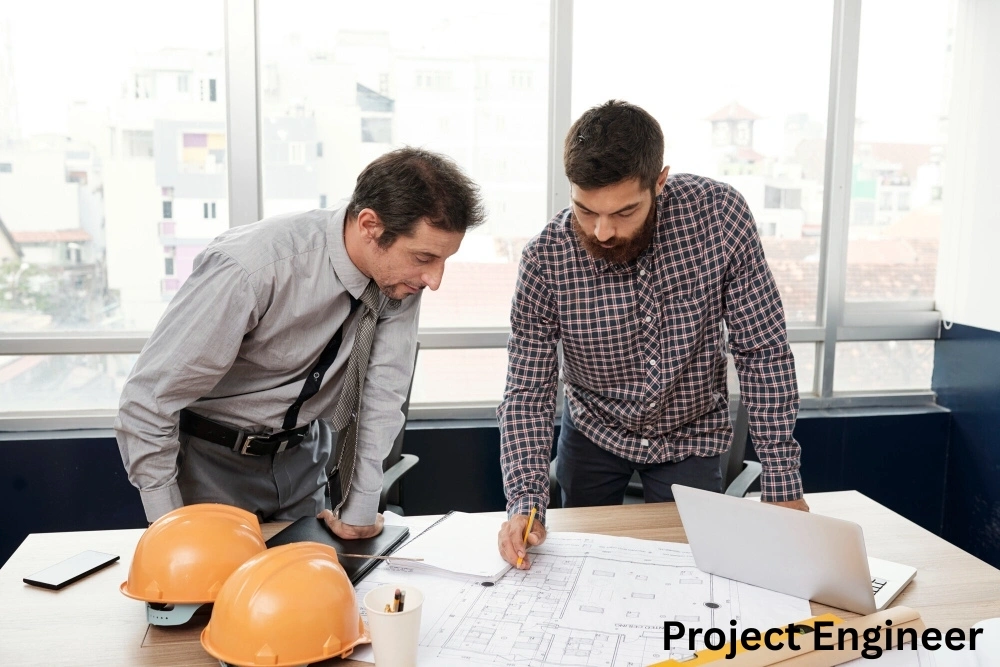 Project engineer reviews blueprints with a manager, pointing out details on the architectural plans in an office